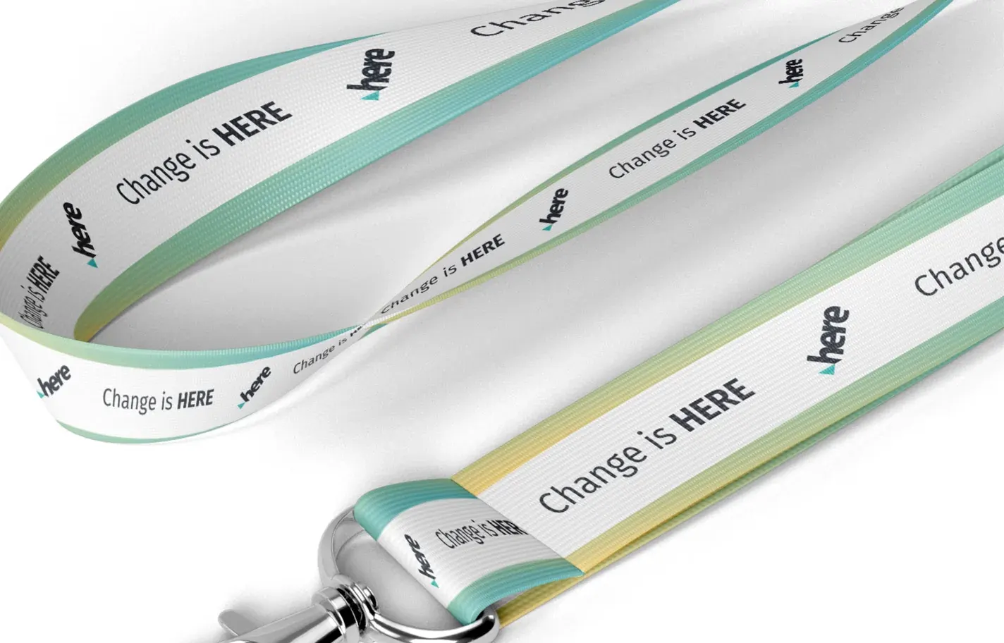 White lanyards printed with the HERE logo and Change is HERE, edged in the brand gradient