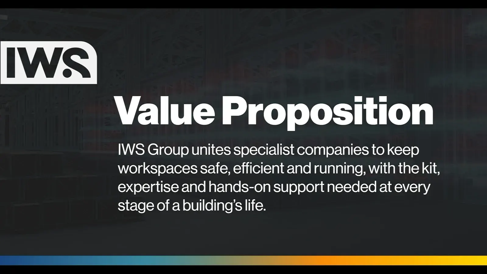 A frame from the IWS brand and values film, with the IWS mark and the group's value proposition over a dark warehouse, above the gradient band.