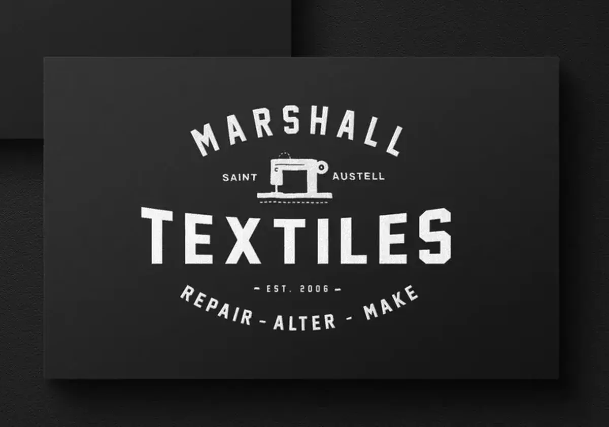Two black Marshall Textiles business cards, one showing the badge logo and the other the owner's contact details.