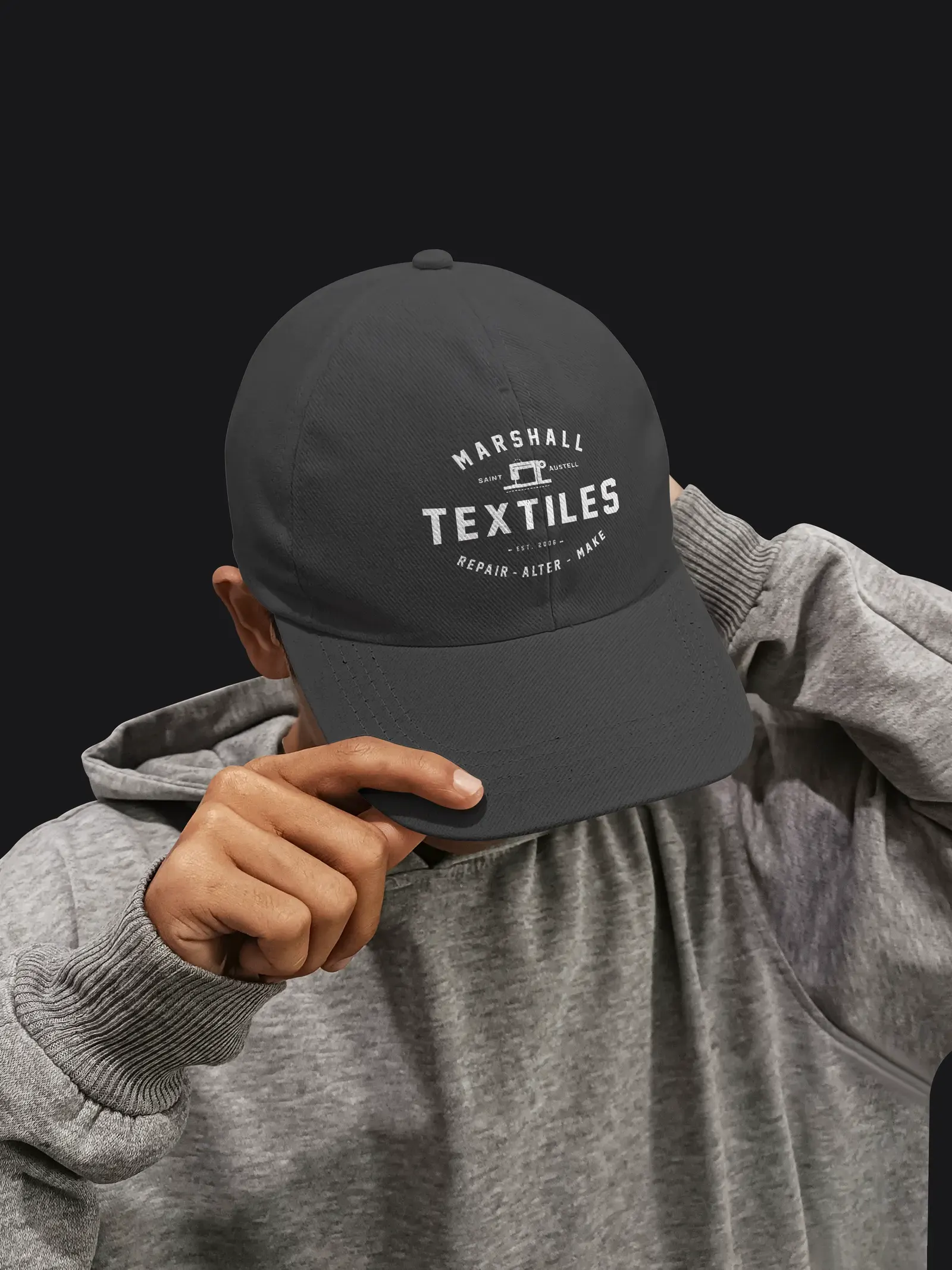 A dark grey cap with the Marshall Textiles badge embroidered on the front.